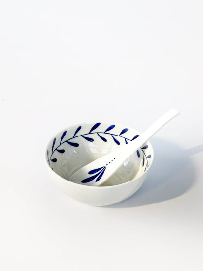 White ceramic bowl with blue leaf pattern on a white background